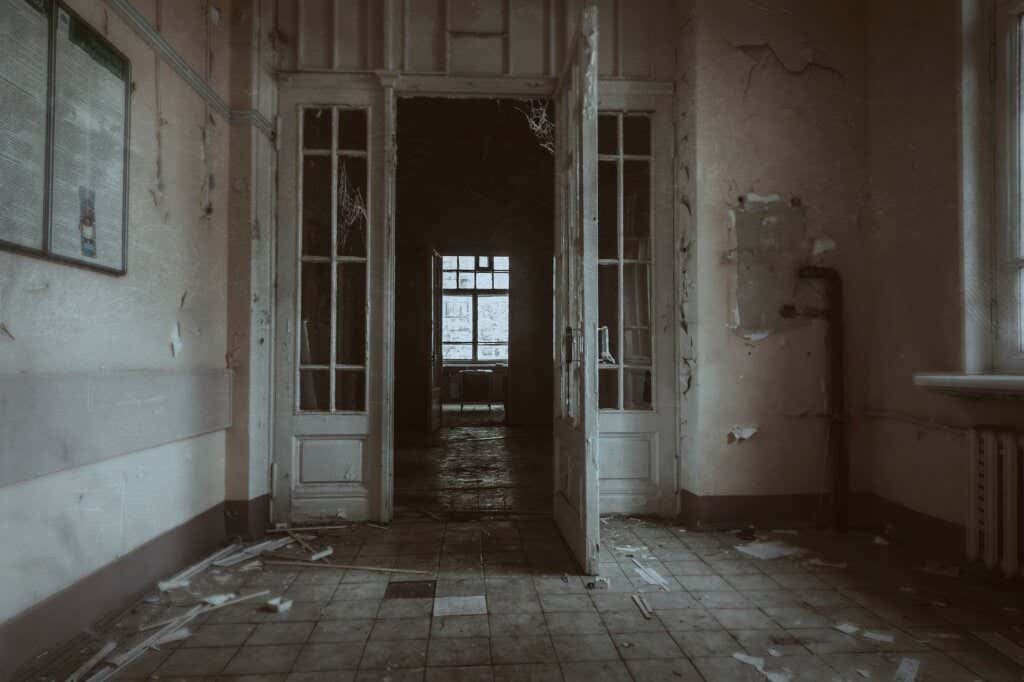 Puerta abierta y pasillo desolado de un hospital psiquiátrico
