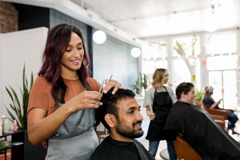 Hairdresser cuts a man's hair