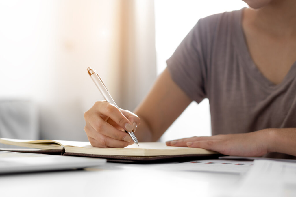 Personne écrivant ses expériences dans un journal comme exemple de sa pratique de gratitude lorsqu'elle est déprimée