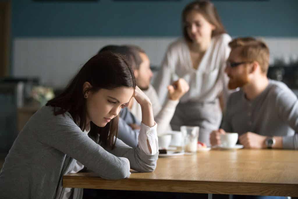 Isolated young woman next to a group of people having a conversation