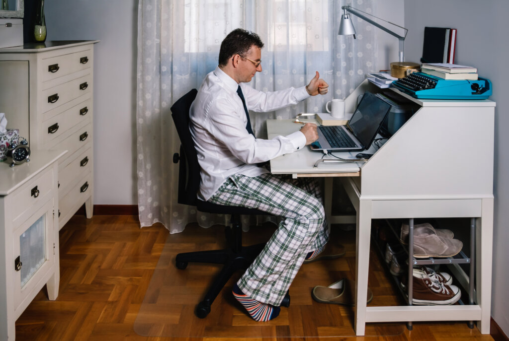 Pracownik w piżamie uczestniczy w wirtualnym spotkaniu, aby przekazać informację zwrotną w ramach motywacji podczas pracy z domu