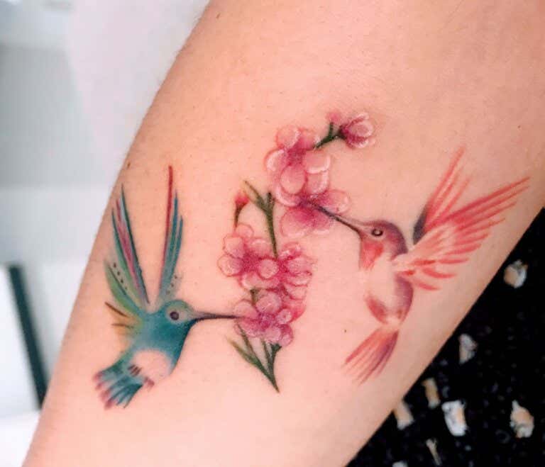 Tatuaje de colibrí y flores