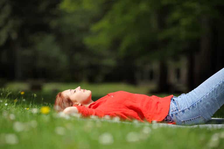 Mujer descansando sobre la hierba se dedica tiempo como propósito de su año nuevo