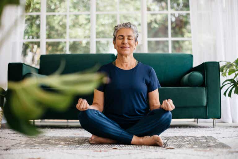 Mujer que practica la meditación en su sala como un propósito clave para la salud mental en este nuevo año