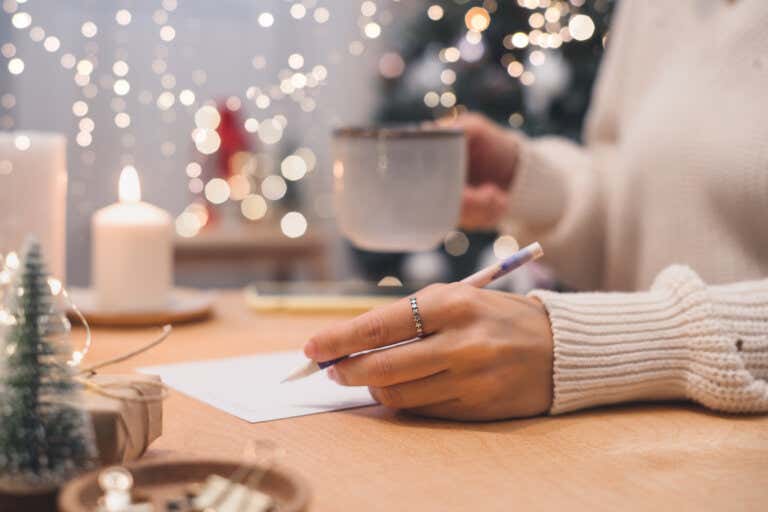 Mujer escribe listas para manejar sus emociones en Navidad.