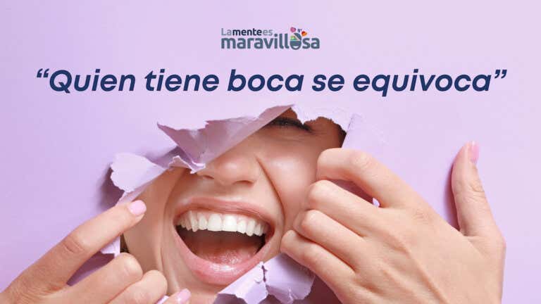 Mujer rompe papel lila y se ve su sonrisa aludiendo a uno de los refranes españoles: "quien tiene boca se equivoca"