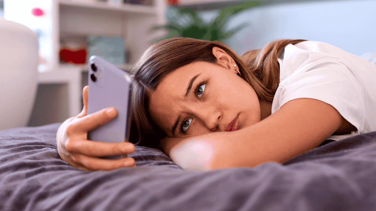 Trieste tiener kijkt naar haar mobieltje