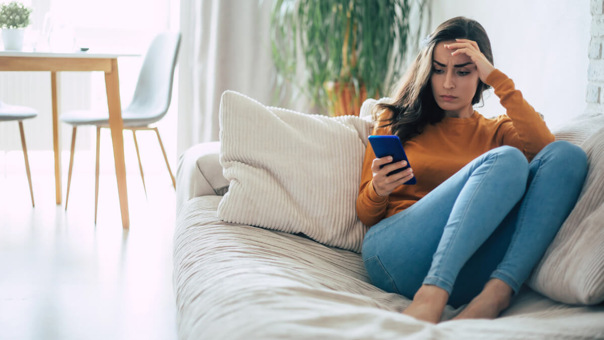 Femme inquiète sur son téléphone.