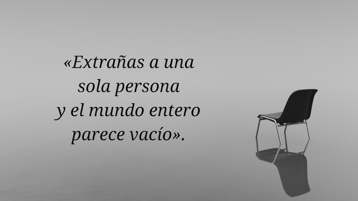 Frase sobre extrañar a alguien escrita junto a una silla vacía