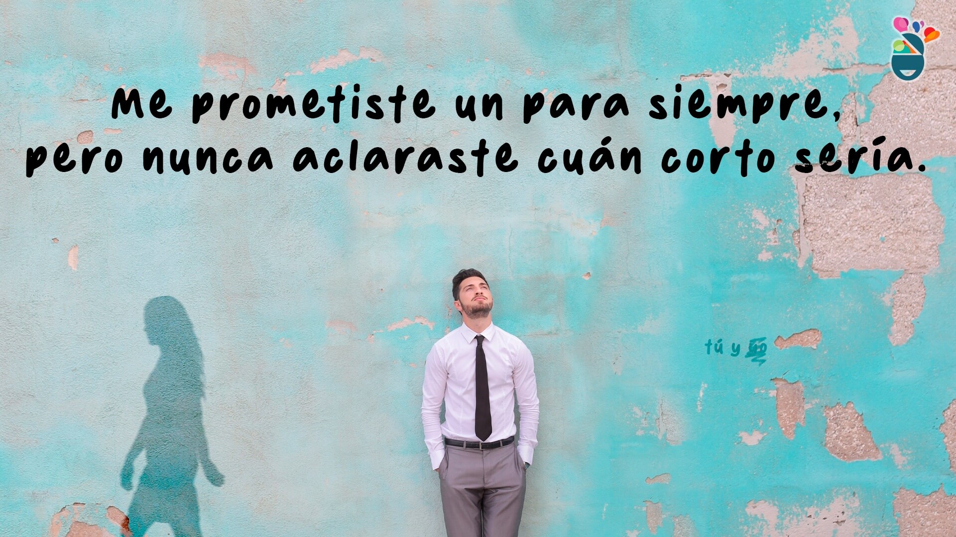 Hombre delante de una pared azul en la que se ve la sombra de su amor que lo abandona